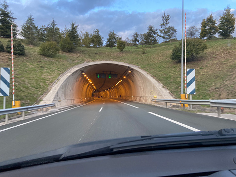 Entrance to a tunnel on a Spanish highway. Car driving by the righ channel.