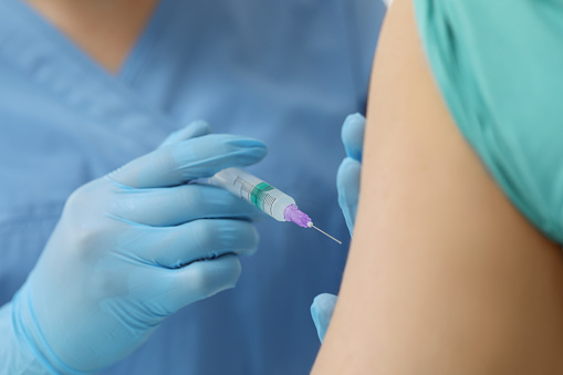 Doctor giving hepatitis vaccine to patient, closeup