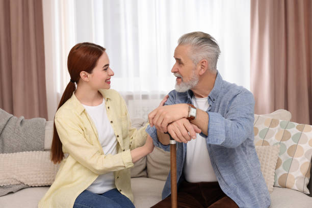 istock Caregiver and senior man with walking cane on sofa at home 1786385849