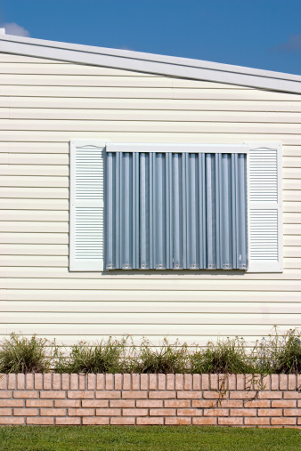 Hurricane protection corrugated metal panels installed on tropical home