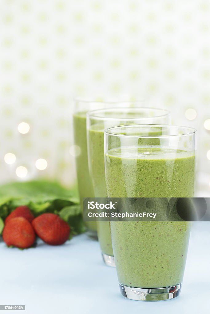 Spinach Smoothie Delicious freshly made Spinach and Strawberry smoothies made with cold milk, yogurt, fresh spinach and strawberries. Shallow depth of field with selective focus on glass in foreground. Blended Drink Stock Photo
