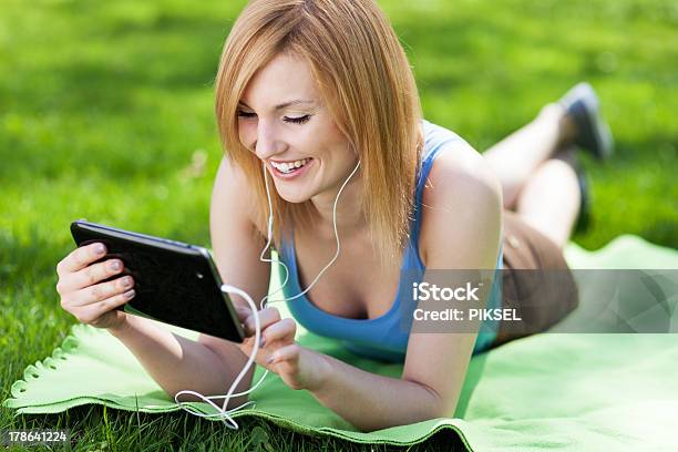 Woman Lying On Grass With Digital Tablet Stock Photo - Download Image Now - Adult, Adults Only, Beautiful People