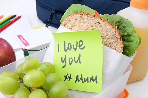 Lunchbox filled with sandwich, fruit and yogurt with secret message