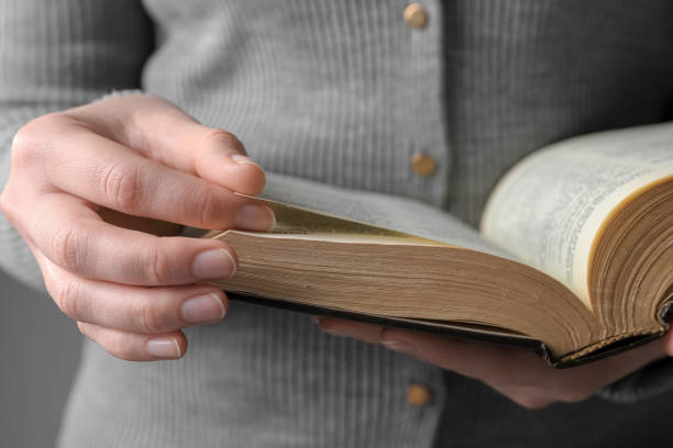 istock Woman reading Bible against grey background, closeup 1786413421