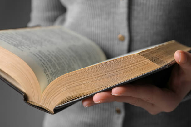 istock Woman reading Bible against grey background, closeup 1786414486