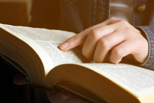 istock Woman reading old holy Bible on blurred background, closeup 1786415031