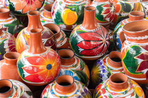 Close up on sets of colorful hand painted Mexican ceramic pots, traditional pottery found at a market stall in Old Town, a state historic park in San Diego, California, USA