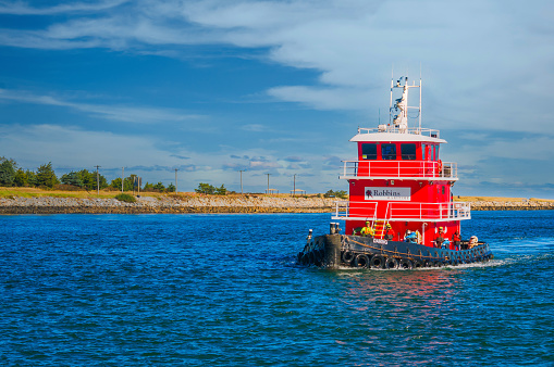 Sandwich, Massachusetts, USA -November 9, 2023 - Crewmen stand on the front deck of the tug boat \