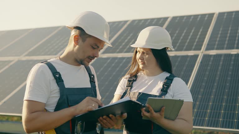 Portrait of workers in front of solar panels discussing information data