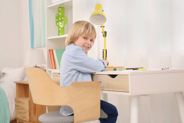 istock Boy sitting at desk in room. Home workplace 1786489142