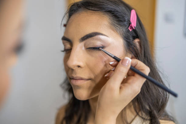 istock Makeup artist applying the eyeshadow, with a brush on a female client in the make up studio. 1786502112