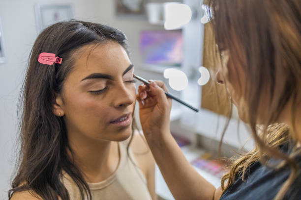 istock Makeup artist applying the eyeshadow, with a brush on a female client in the make up studio. 1786503172