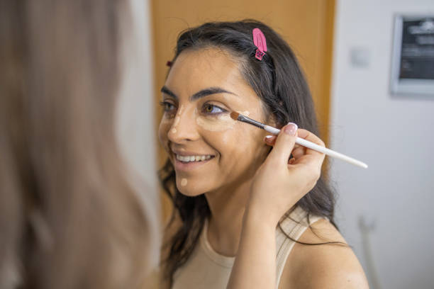 istock Make-up artist at a beauty salon applying a make-up concealer with a blush on a beautiful young woman. 1786512077