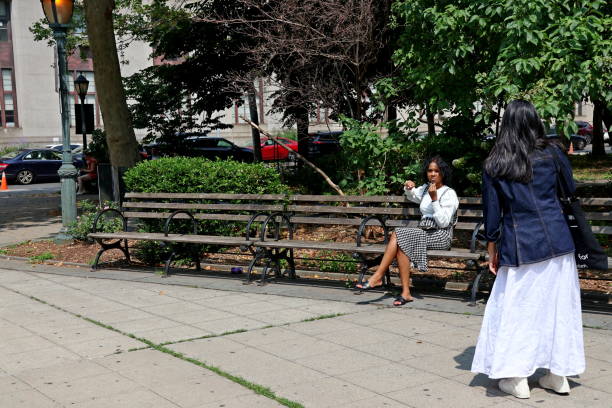 Young elegantly dressed African American woman sitting on a bench in NYC