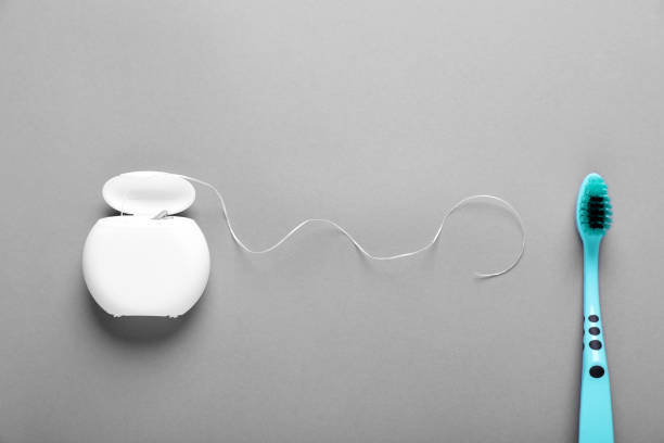 istock Container with dental floss and toothbrush on light grey background, flat lay 1786549461