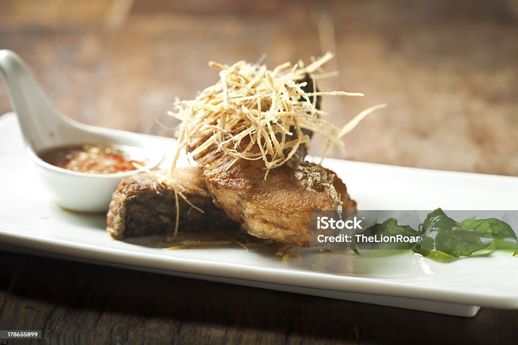 Pescado frito cubierto con una salsa de pescados y mariscos - Foto de stock de Alimento libre de derechos