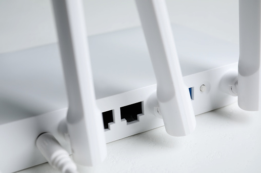 New modern Wi-Fi router on white table, closeup