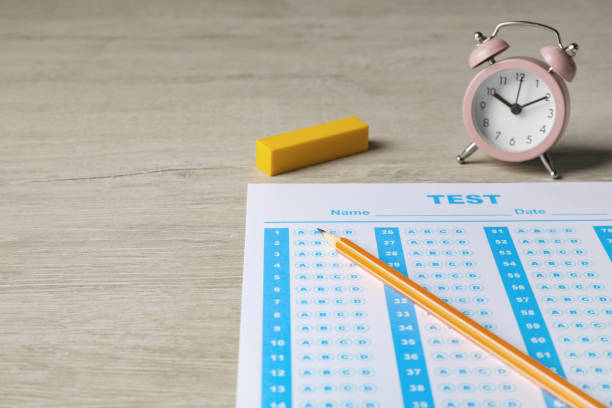 istock Answer sheet, pencil and alarm clock on wooden table, space for text. Student passing exam 1786563020