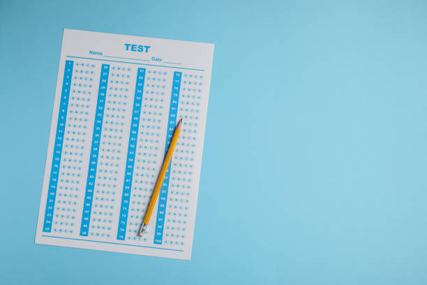 Answer sheet and pencil on light blue background, top view with space for text. Student passing exam