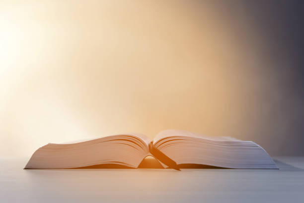 istock Open Bible on white wooden table against beige background. Space for text 1786579370