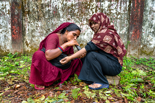 A nomadic gypsy healer from Bangladesh blows through her horn to cure a patient