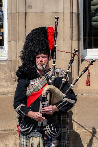 Edinburgh Scotland - June 3 2023: A Scottish Man Playing the Bagpipes in Old City Edinburgh Scotland