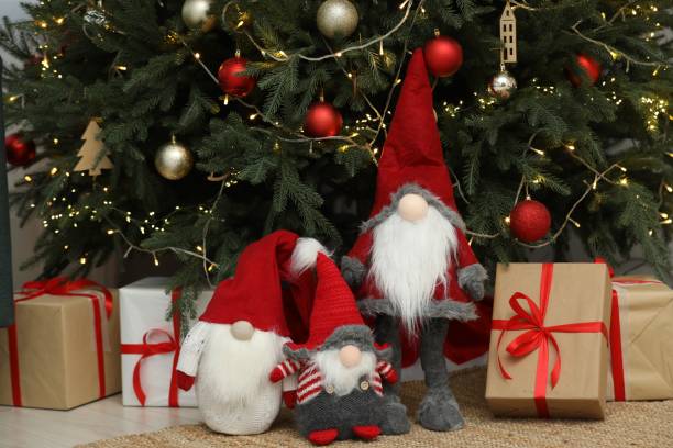 istock Funny decorative gnomes and gift boxes under Christmas tree indoors 1786593781