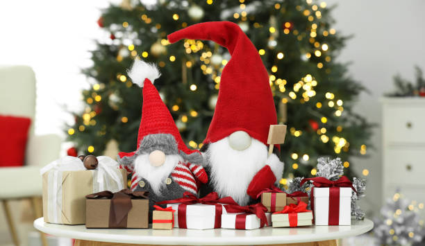 istock Funny Christmas gnomes and gift boxes on coffee table in room with festive decoration 1786597405