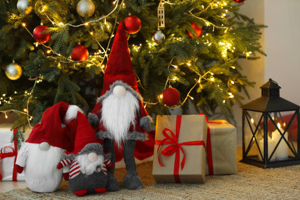 istock Funny decorative gnomes and gift boxes under Christmas tree indoors 1786597923