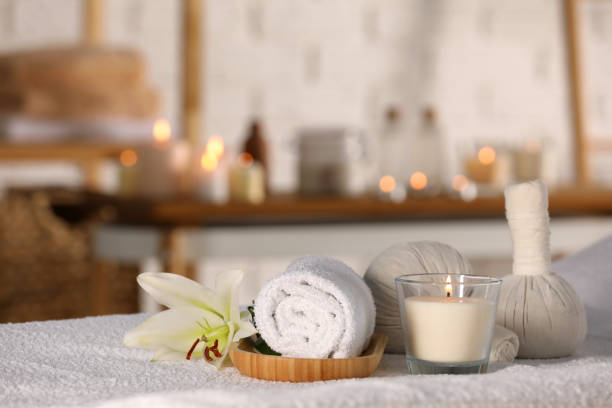istock Spa composition with burning candle and herbal bags on massage table in wellness center 1786617898