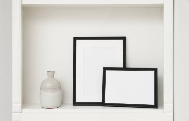 istock Blank frames and ceramic vase on shelving unit indoors 1786618969