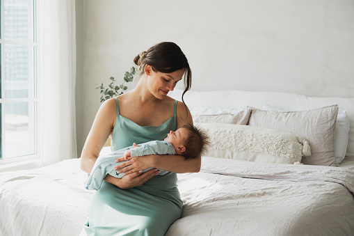Loving mom carying of her newborn baby at home. Lifestyle concept.
