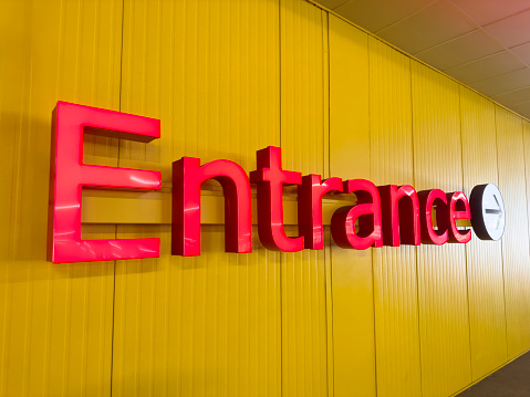 Entrance sign of a retail place on a colored wall