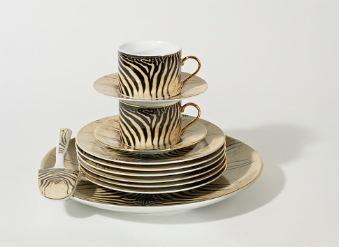 Still life of crafted crockery set with coffee cups on white background