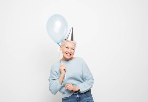 istock Portrait of elderly lady holding blue balloon having fun 1786682462