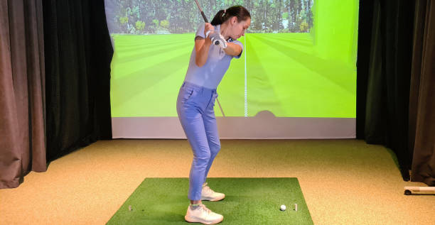 istock Girl playing golf on screen and golf simulator 1786727775