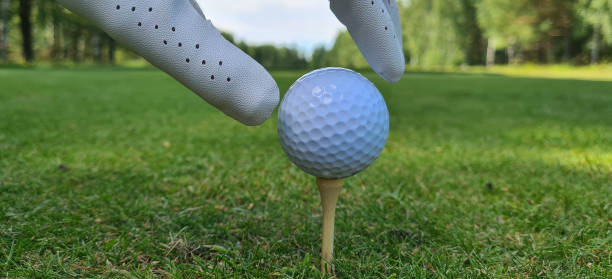 Closeup hand holding golf ball. Hand holding golf ball on golf tee Closeup hand holding golf ball. Hand holding golf ball on golf tee concept golfer swinging club stock pictures, royalty-free photos & images