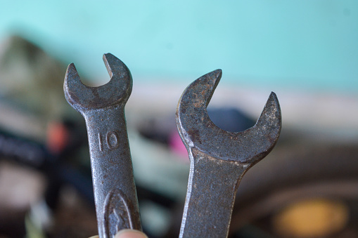 Photo of hand holding 2 wrenches. No people.