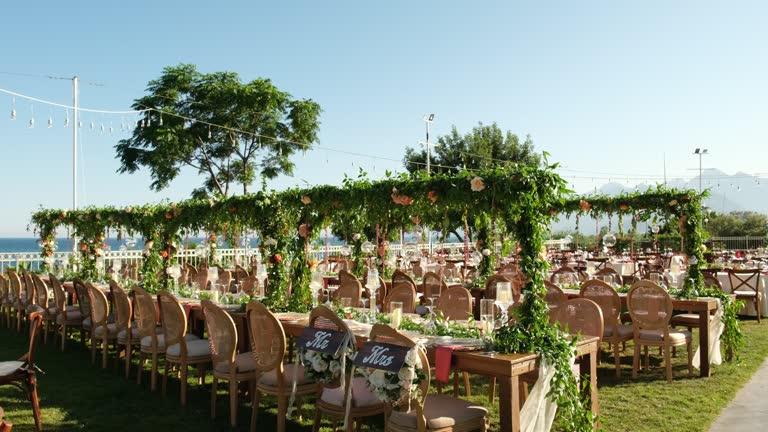 Table setting and bride and groom table at a wedding banquet decorated with flowers