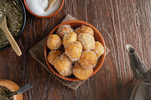 Argentine fritters coated in sugar accompanied by mate and kettle.