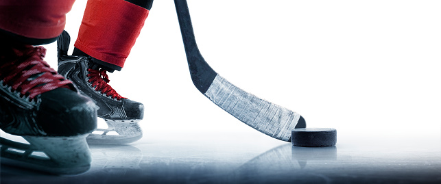 Hockey puck and stick close-up. Hockey player in ice rink. Focus on the puck. Hockey concept. Ice. Isolated. Sport