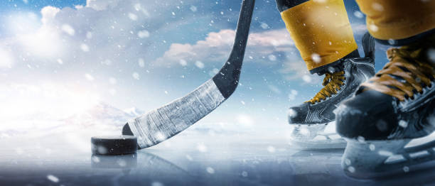 Hockey puck and stick close-up. Hockey player in ice rink. Focus on the puck. Hockey concept. Ice. Outdoor skating rink Hockey puck and stick close-up. Hockey player in ice rink. Focus on the puck. Hockey concept. Ice. Outdoor skating rink. Sport hockey skates stock pictures, royalty-free photos & images