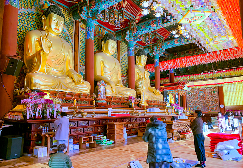 Carving stone and sculpture rock buddha image statue on stone wall for thai people travel visit respect praying blessing worship in Wat Maniwong temple on September 6, 2022 in Nakhon Nayok, Thailan