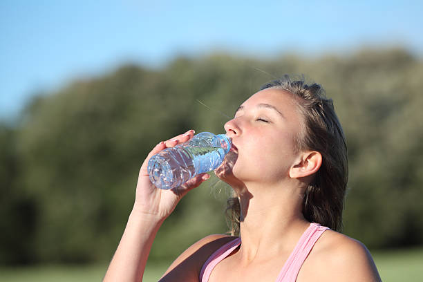 istock Woman drinking water from a plastic bottle in the mountain 178702267