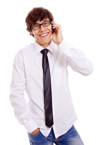 Smiling young man in white shirt, blue jeans and black glasses talking by mobile phone. Isolated on white background, mask included