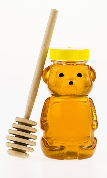istock Honey in a container with wood dipper. 178702589