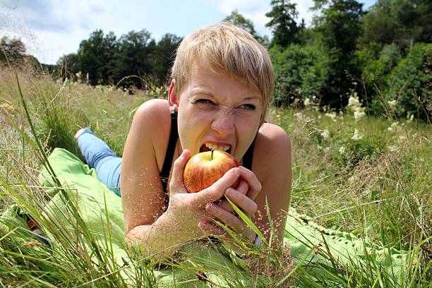 istock girl with apple on summer meadow 178702903