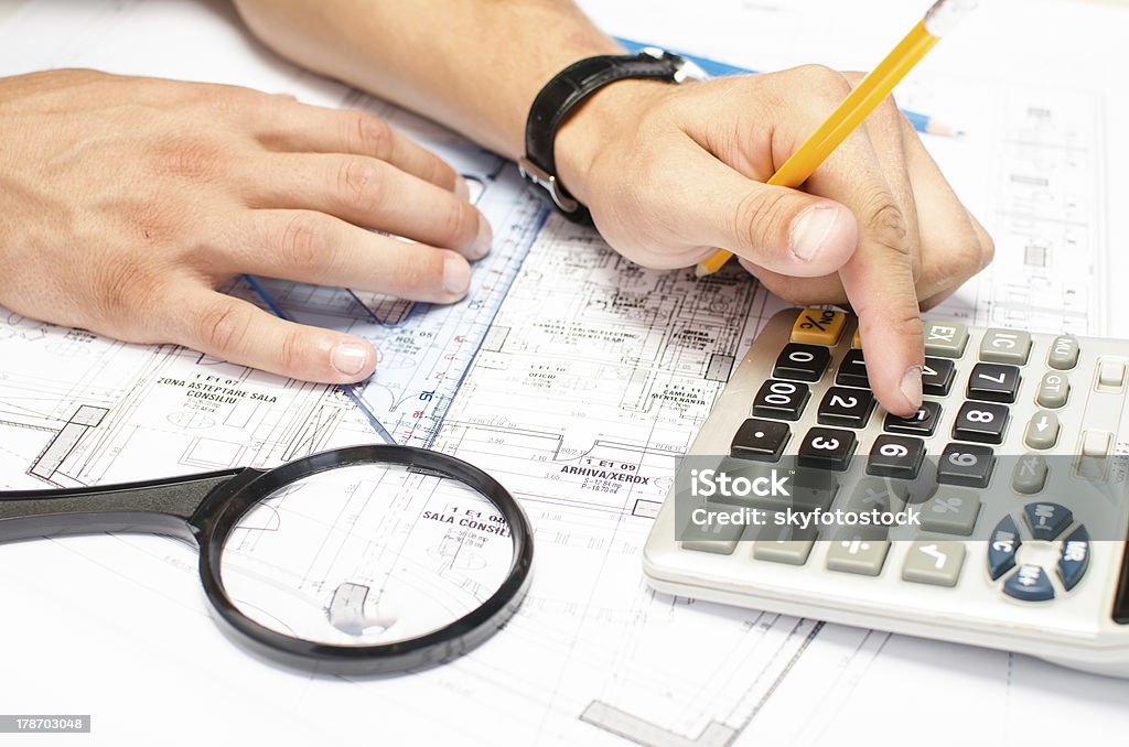 Hombre trabajando con una calculadora y cuadrada dibujo - Foto de stock de Arquitecto libre de derechos