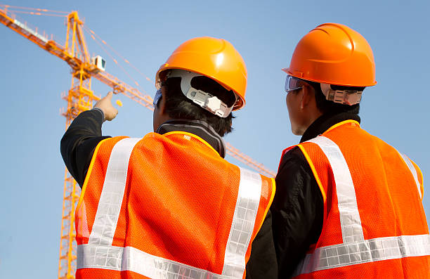 istock Rear view of construction workers pointing to distant crane 178703429