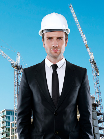 Young architect wearing a hardhat in a construction site